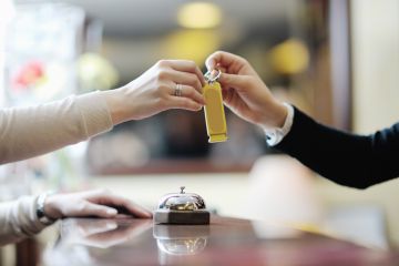 Gast erhält Zimmerschlüssel an der Hotelrezeption